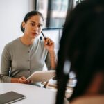 Serious ethnic psychotherapist listening to clients as they engage in storytelling.