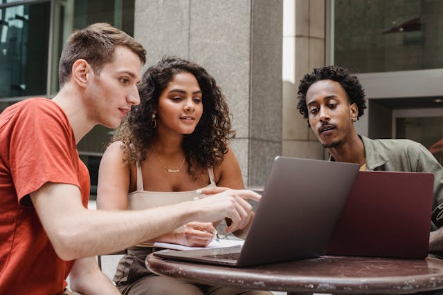 Group of multiethnic coworkers discussing startup project on laptops