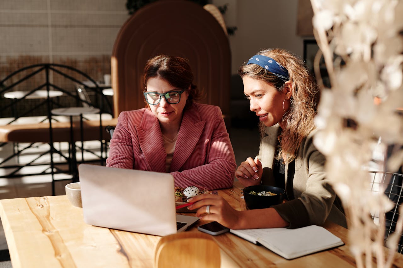 Woman in Red Knit Sweater Sitting by the Table having an authentic conversation with another woman.